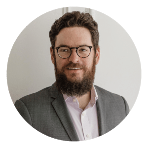 A photograph of Neil Fitzroy, Managing Director - Australasia for Oxford International Education Group - sitting on a sofa infront of a neutral wall