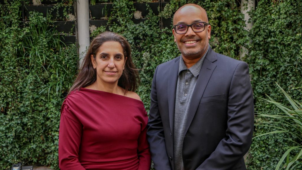 Oxford International CEO Lil Bremermann-Richard stands next to Whitecliffe University of Applied Sciences MD Feroz Ali. They are standing in front of a leafy green background and are both smiling.