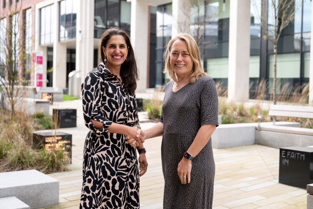 Lil Bremermann-Richard, CEO of Oxford International and Professor Liz Mossop, Sheffield Hallam University Vice-Chancellor shaking hands in front of the university building