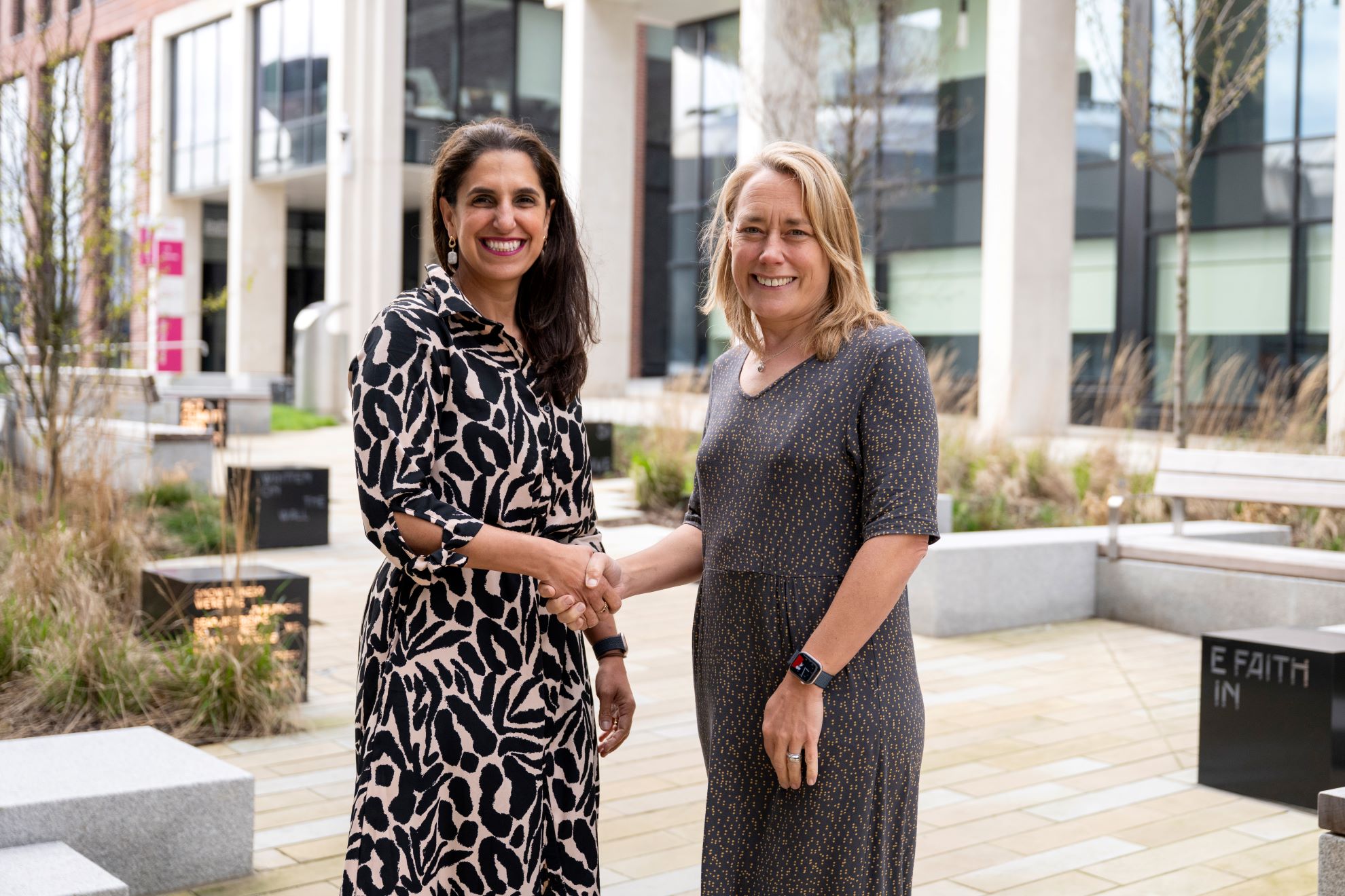 Lil Bremermann-Richard, CEO of Oxford International and Professor Liz Mossop, Sheffield Hallam University Vice-Chancellor shaking hands in front of the university building